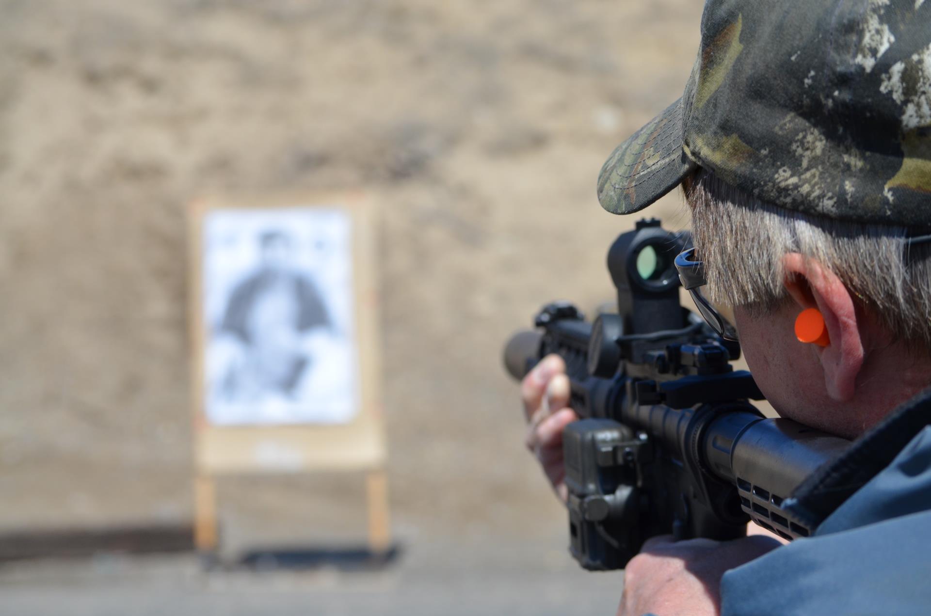 A man aiming a rifle to a target